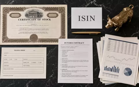 CME Group Inc. Flatlay mit Aktienzertifikat und ISIN-Karte, US12572Q1058 inmitten von Finanzinstrumenten arrangiert - Foto: THN