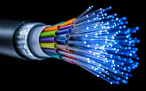 Comcast Corp. Glasfaserkabel Makro mit leuchtenden Lichtpunkten auf schwarzem Hintergrund, US20030N1019 Telekommunikation Detail - Foto: THN