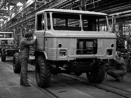 Traton SE DE000TRAT0N7 dokumentiert schwarzweiße Reportage über sorgfältige Lkw-Montage in europäischer Fabrikhalle heute - Foto: THN