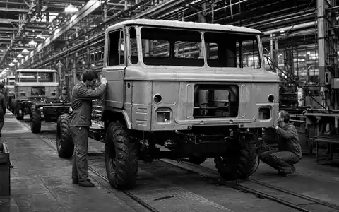 Traton SE DE000TRAT0N7 dokumentiert schwarzweiße Reportage über sorgfältige Lkw-Montage in europäischer Fabrikhalle heute - Foto: THN