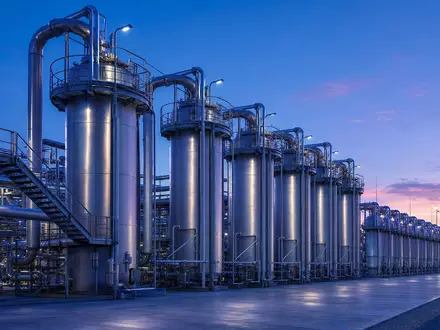 ThyssenKrupp Nucera (DE000NCA0001) betreibt eine große industrielle Wasserstoff-Elektrolyseanlage in der Abenddämmerung mit Rohren - Foto: THN