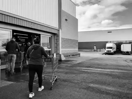 TJX Companies Inc. (US8725401090) beliefert Filialen per Lkw, dokumentarisches Schwarzweißfoto eines Warenlagers - Foto: THN