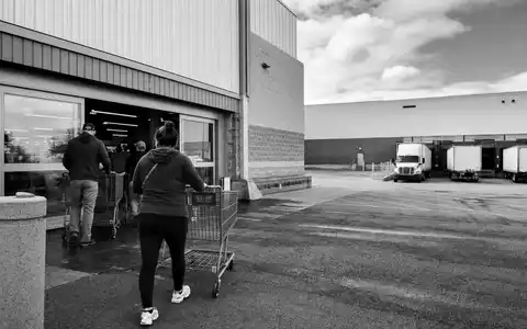 TJX Companies Inc. (US8725401090) beliefert Filialen per Lkw, dokumentarisches Schwarzweißfoto eines Warenlagers - Foto: THN