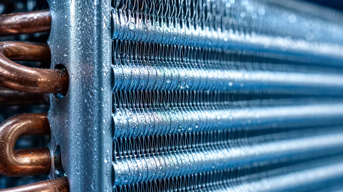Extreme Nahaufnahme eines Aluminium-Wärmetauschers mit Kupferrohren und Tropfen