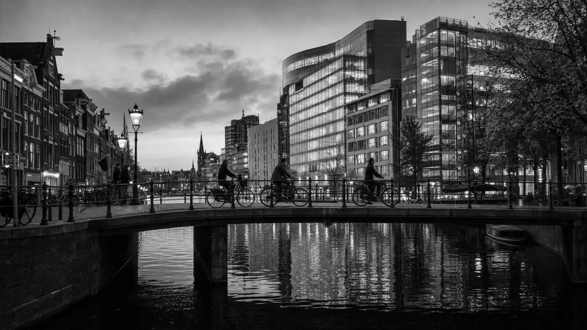 Schwarzweiß Amsterdam Gracht Brücke mit Fintech-Bürogebäuden – Adyen N.V. NL0012969182