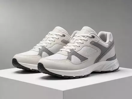 Adidas AG (DE000A1EWWW0) – Fotorealistische Studio-Aufnahme generischer ungebrandeter Sportschuhe auf weißem Podest - Foto: THN