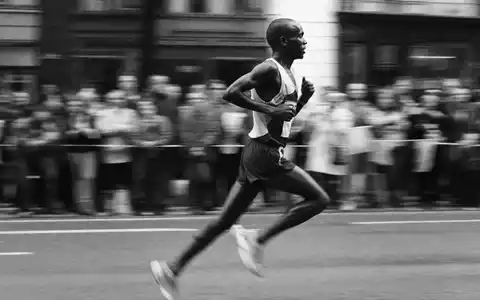 Adidas AG (DE000A1EWWW0) – Schwarz-Weiß-Reportagefoto eines Laufsportlers im Wettkampf auf der Strecke - Foto: THN