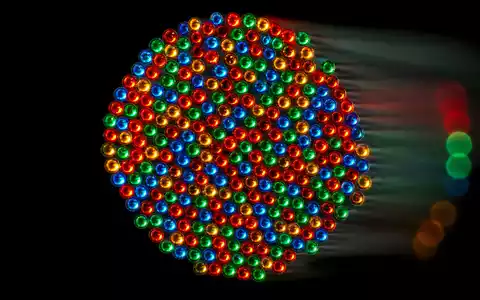 Adtran Networks SE DE000A14U784 – extreme Makrofotografie leuchtender Glasfaser-Kabelenden mit farbigen Lichtpunkten auf schwarzem Hintergrund - Foto: THN