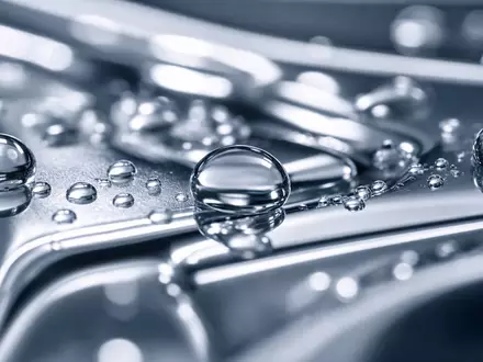 A.O. Smith Corp. Wasser und Metall als extreme Makroaufnahme von Tropfen auf Chrom ISIN US0003711006 - Foto: THN