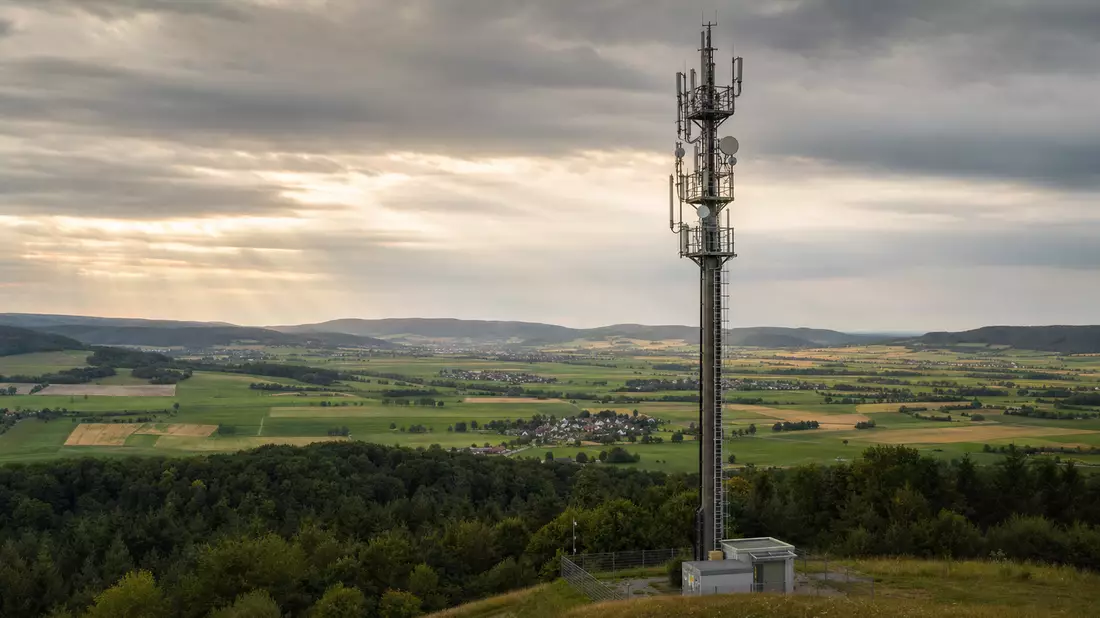 Fotorealistischer 5G-Mast in deutscher Landschaft, Weitwinkelaufnahme