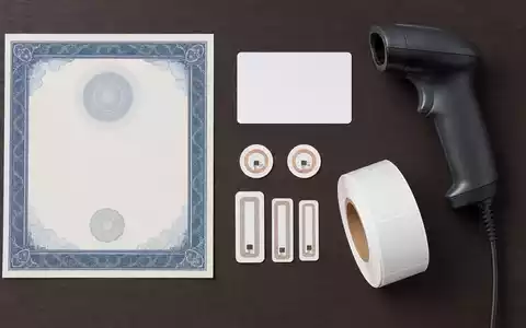 Zebra Technologies (US9892071054) Flatlay mit Aktienzertifikat, ISIN-Karte, Barcode-Scanner und kleinen RFID-Etiketten arrangiert - Foto: THN