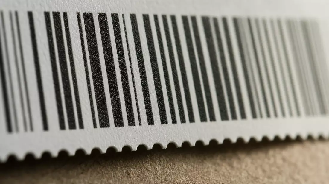 Makroaufnahme eines Barcode-Etiketts mit scharfen Balken und Papierstruktur