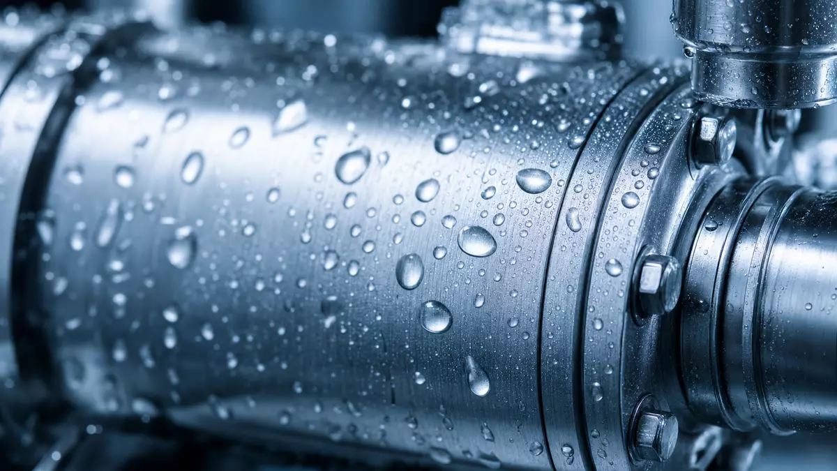Makroaufnahme von Wassertropfen auf gebürsteter Edelstahloberfläche einer Pumpe
