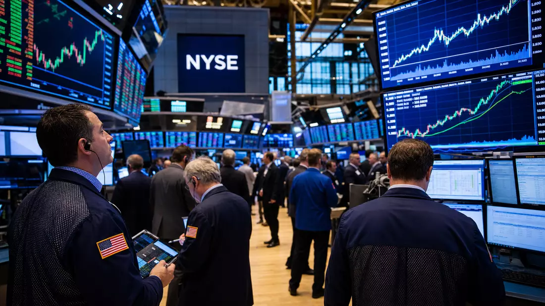 Trading-Floor der New Yorker Börse mit Händlern vor Kursbildschirmen und NYSE-Schriftzug