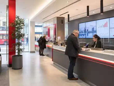 Fotorealistische Bankfiliale symbolisiert Virgin Money UK PLC (ISIN GB00BD6GN030) im britischen Retail-Bankensektor mit modernem Design - Foto: THN