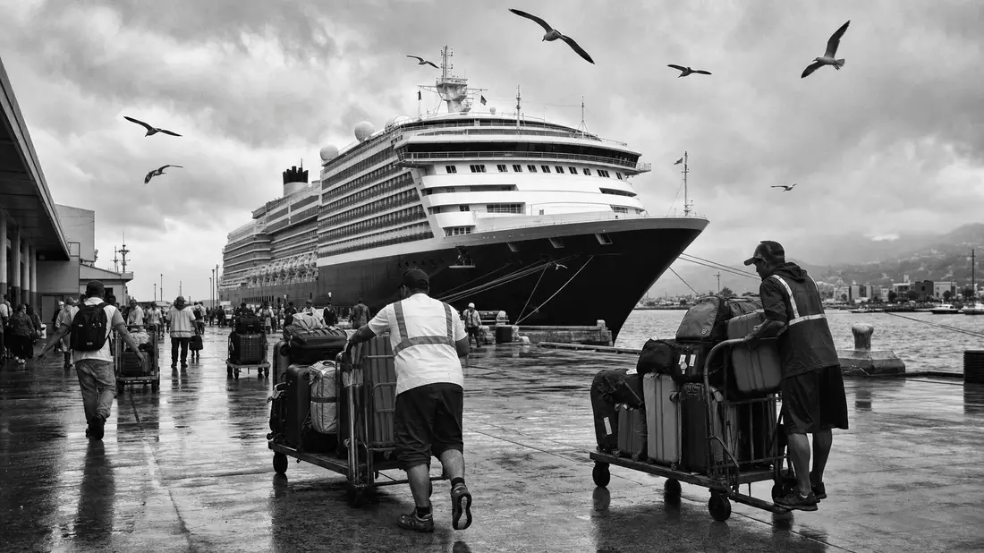 Schwarz-weiße Reportage einer Hafenszene mit generischem Kreuzfahrtschiff