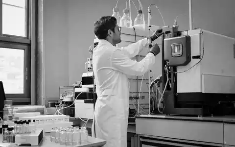 Waters Corporation (ISIN US9418481035) dokumentiert in Schwarzweiß einen Techniker an chromatographischen Analysegeräten im Labor - Foto: THN