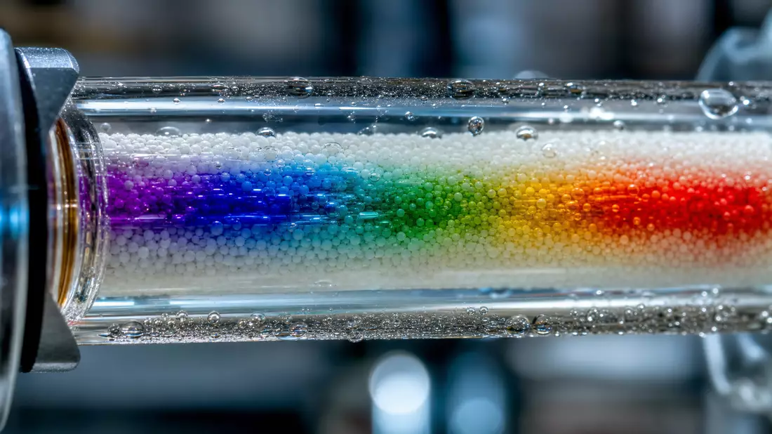 Makroaufnahme einer Chromatographiesäule mit bunten Farbverläufen im Glas