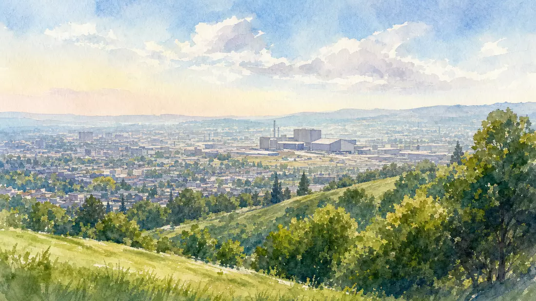 Aquarellmalerei einer Stadtlandschaft mit ferner Industrieanlage vor grünen Hügeln
