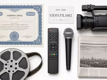 Fox Corp. (Class A) US35137L1052 Flatlay-Arrangement zeigt Aktienzertifikat ISIN-Karte und branchentypische Medien-Utensilien - Foto: THN
