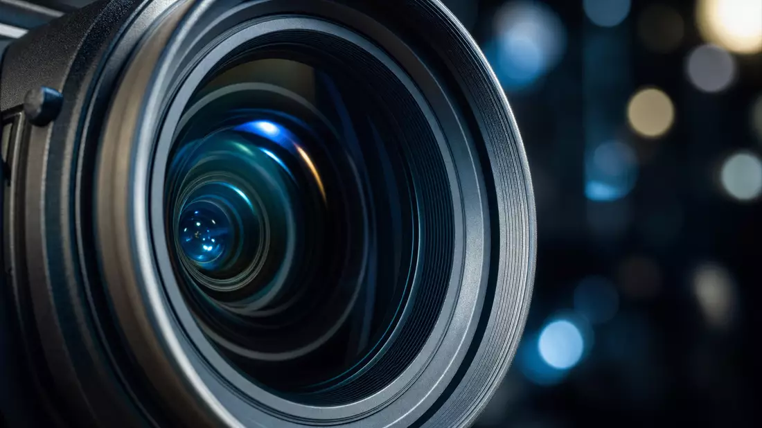 Extreme Makro-Nahaufnahme einer Broadcast-Kameralinse mit blauen Bokeh-Reflexionen