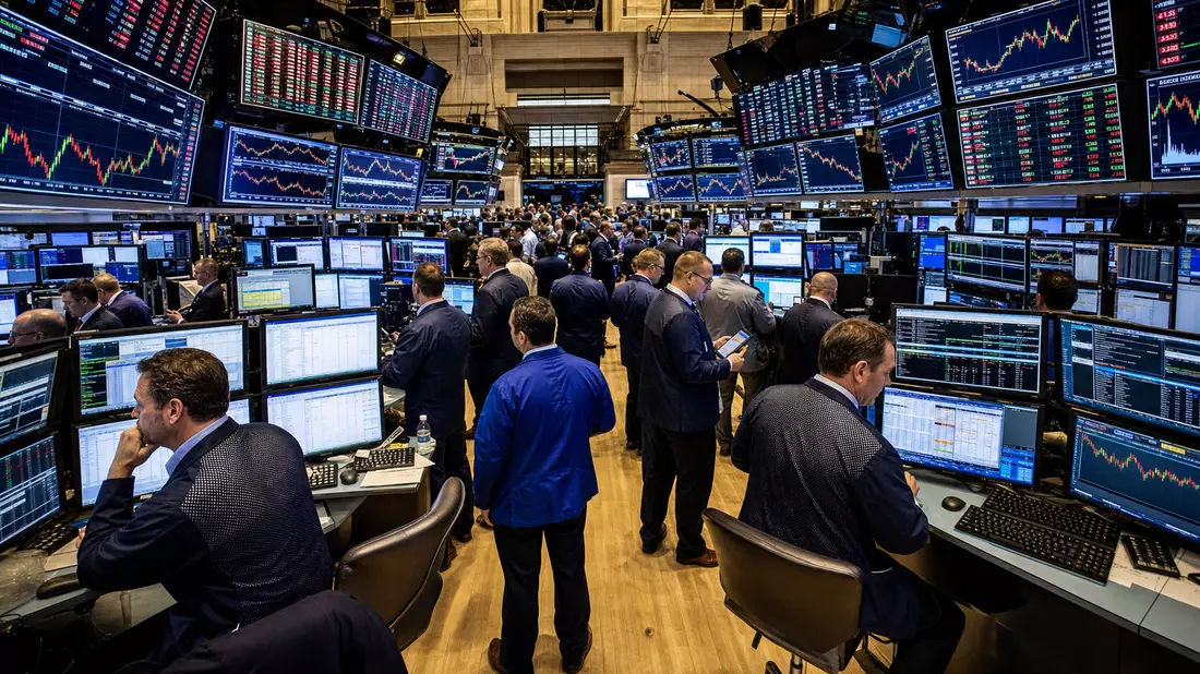 Geschäftiger NYSE-Handelsparkett mit Tradern und Monitoren mit Mediensektor-Kurscharts