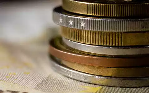Banco Santander (ISIN ES0113900J37): extreme Makroaufnahme von gestapelten Euro-Münzen mit feinen Metalltexturen - Foto: THN