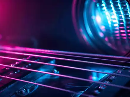 Live Nation Entertainment (ISIN US5380341090) steht für Live-Musik, hier eine Makroaufnahme von Gitarrensaiten und Bühnenlicht - Foto: THN