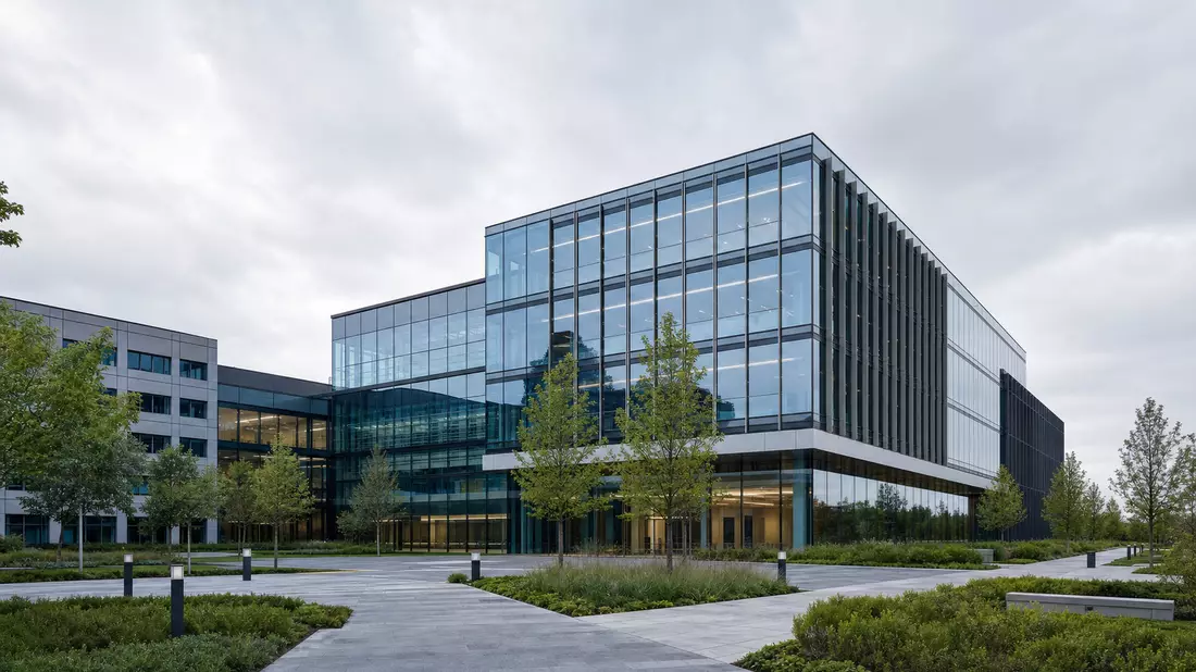 Architekturrender eines modernen Firmenhauptsitzes aus Glas und Stahl mit Grünanlagen