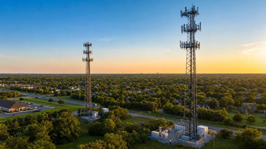 Fotorealistisches Luftbild zweier Stahlgittermasten mit Antennenanlagen bei Sonnenuntergang