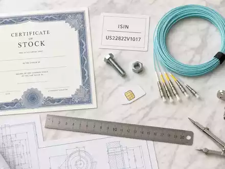 Crown Castle Inc. Flatlay US22822V1017 zeigt Aktienzertifikat ISIN-Karte Koaxialkabel Antennenbauteil und Blaupause - Foto: THN