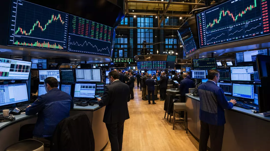 Redaktionsfoto des NYSE-Handelsraums mit Händlern und großen Telekom-Sektorkurs-Displays