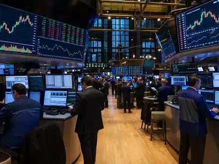 Crown Castle Inc. NYSE-Handelsparkett US22822V1017 zeigt Händler vor Monitoren mit Telekommunikationssektor-Charts bei Hochbetrieb - Foto: THN