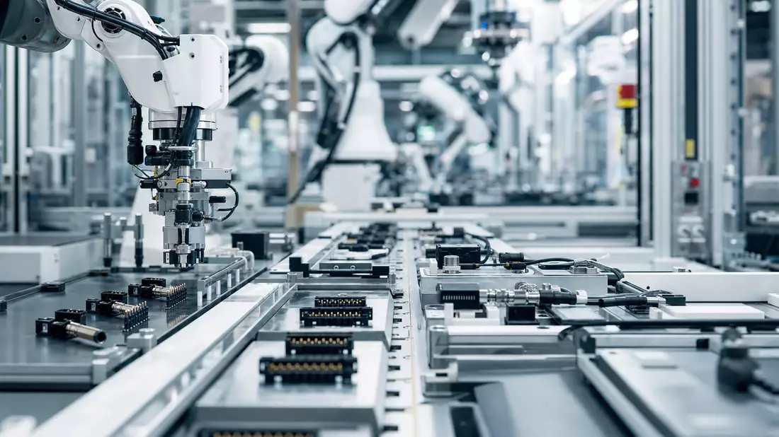 Automatisierte Fertigungslinie mit Roboterarmen und elektronischen Steckverbindern in moderner Fabrikhalle