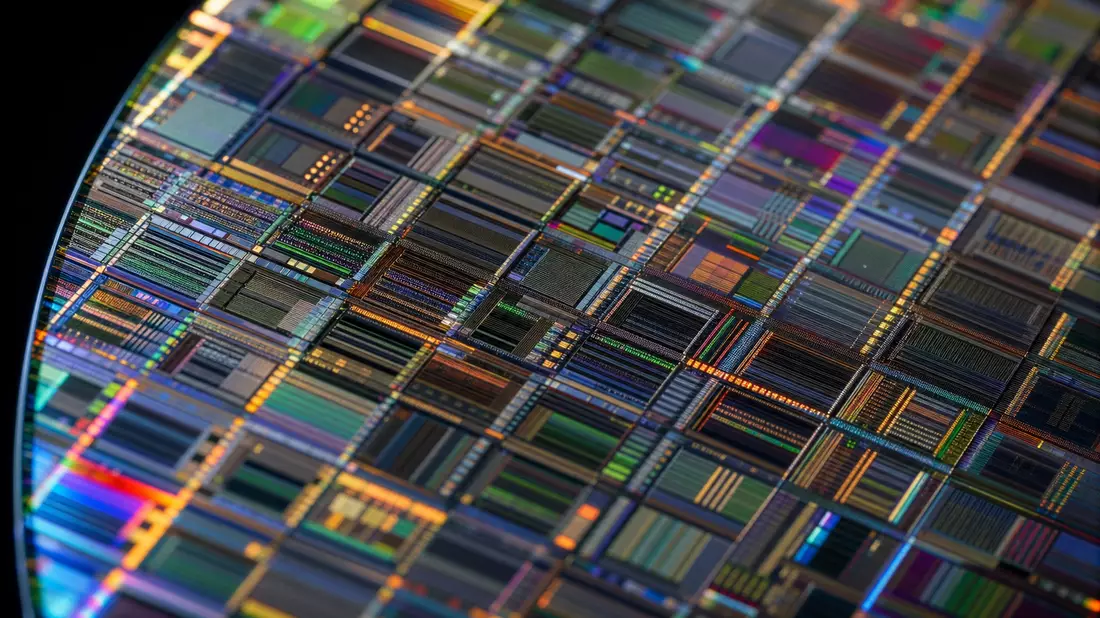 Extreme Makroaufnahme einer Siliziumwafer-Oberfläche mit schillernden Schaltkreismustern