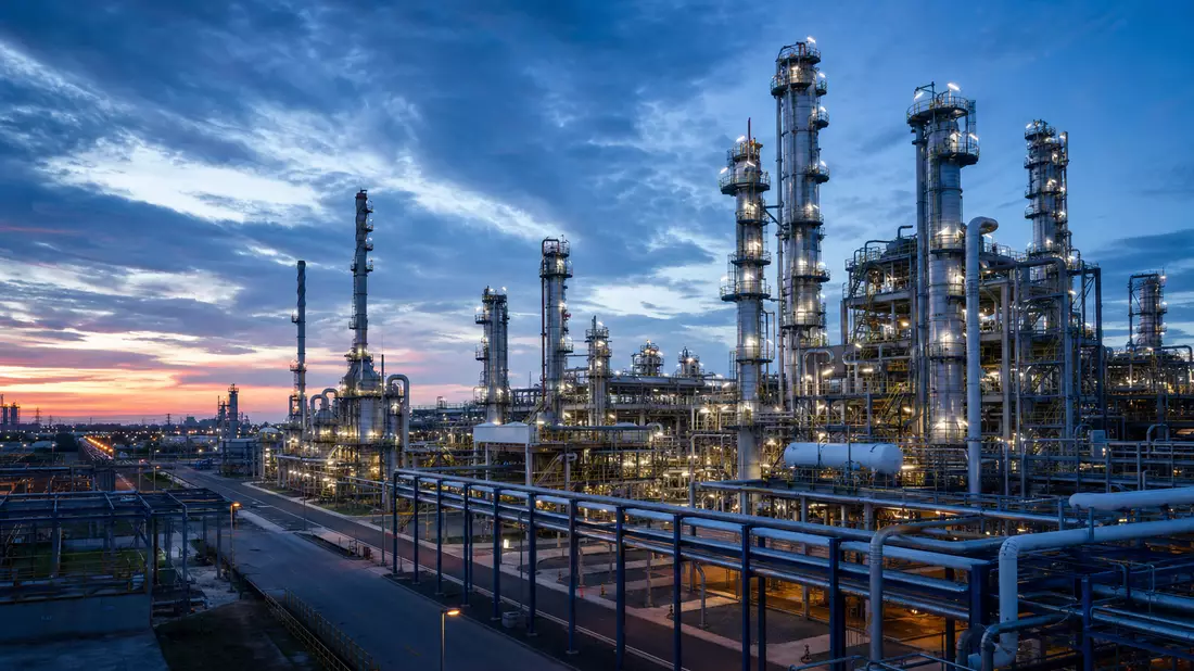 Architektonisches 3D-Rendering einer petrochemischen Raffinerie mit Destillationstürmen in der Dämmerung