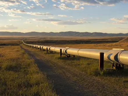 ONEOK Inc. (ISIN US6826801036) Erdgas-Pipeline durchquert weite Prärielandschaft im goldenen Abendlicht fotorealistisch - Foto: THN