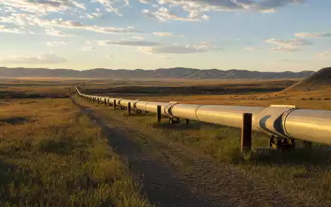 ONEOK Inc. (ISIN US6826801036) Erdgas-Pipeline durchquert weite Prärielandschaft im goldenen Abendlicht fotorealistisch - Foto: THN