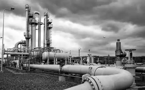 ONEOK Inc. (ISIN US6826801036) Schwarz-WeiĂ-Reportagefoto einer industriellen Erdgas-Kompressorstation mit dramatischem bewölktem Himmel im Hintergrund - Foto: THN