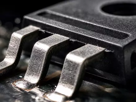 ON Semiconductor US6821891035 zeigt eine detaillierte Makroaufnahme eines Leistungshalbleiter-Gehäuses mit glänzenden Metallanschlüssen und Lötpins - Foto: THN