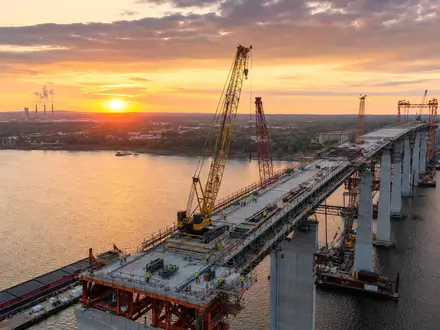 Jacobs Solutions Infrastrukturprojekt zeigt großen Brückenbau über einen Fluss bei Sonnenuntergang, ISIN US4698141098 - Foto: THN