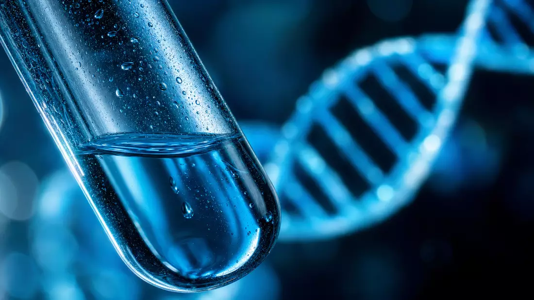 Extreme Nahaufnahme eines Reagenzglases mit leuchtender DNA-Doppelhelix im Hintergrund