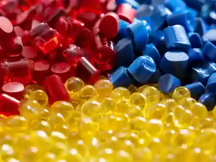 Lanxess AG (DE0005470405) zeigt in scharfer Makroaufnahme bunte glänzende Kunststoffgranulate aus der modernen Chemieproduktion - Foto: THN