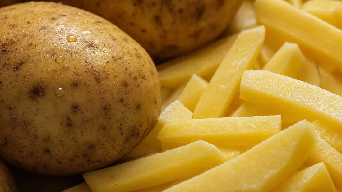 Makrofoto von rohen Kartoffeln und frisch geschnittenen Kartoffelstreifen