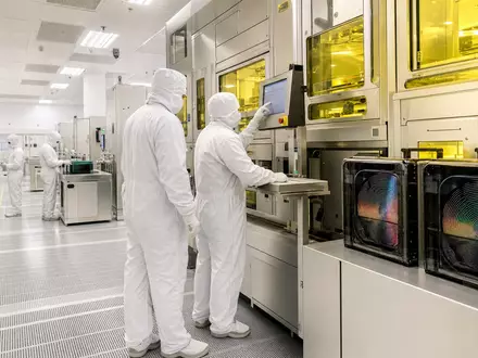 Lam Research (ISIN US5128071082) zeigt fotorealistisch eine Reinraum-Chipfertigung mit modernen Waferanlagen und Technikern - Foto: THN
