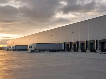 Fotorealistisches Logistiklager zeigt Tritax Big Box REIT plc mit ISIN GB0008847096 und riesiger Lkw-Verladerampe - Foto: THN