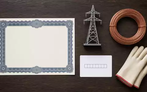 Flatlay mit Aktienzertifikat und Strommast-Modell repräsentiert National Grid plc (GB00BDR05C01) als Energienetz-Betreiber - Foto: THN