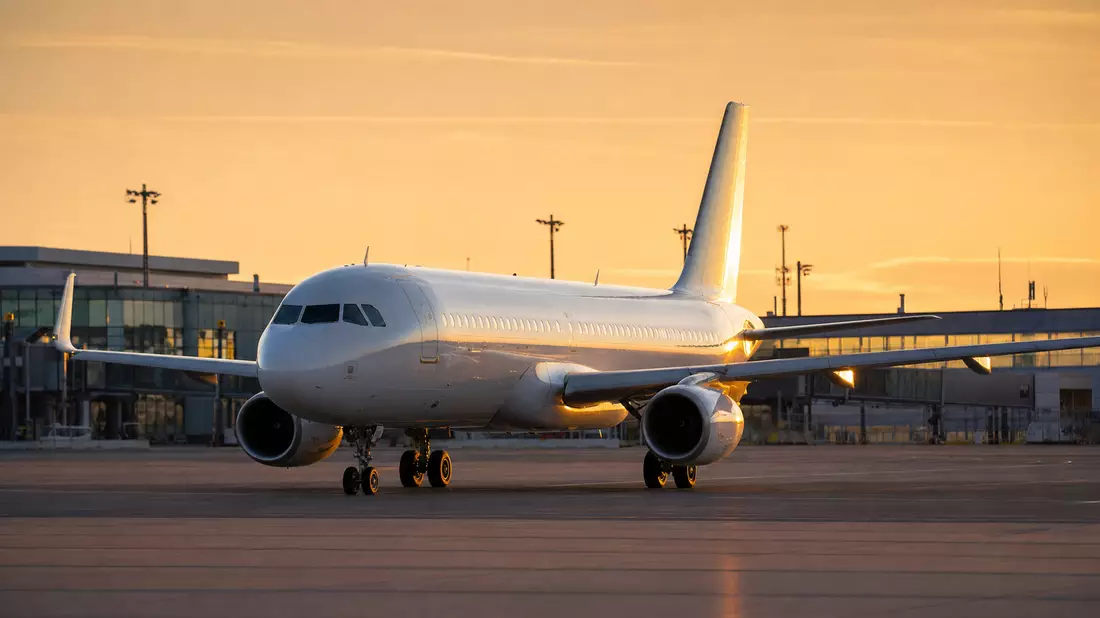 Unbeschriftetes Passagierflugzeug auf Rollfeld bei Sonnenuntergang, Air France-KLM SA
