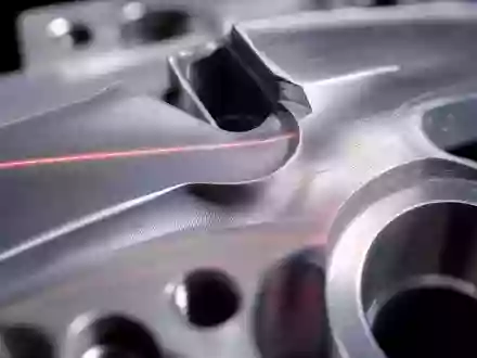 Hexagon AB (SE0015961909) steht für Präzisionsmessung im Mikrometerbereich, sichtbar in dieser Makroaufnahme mit roter Laserlinie - Foto: THN