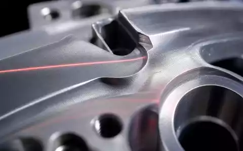 Hexagon AB (SE0015961909) steht für Präzisionsmessung im Mikrometerbereich, sichtbar in dieser Makroaufnahme mit roter Laserlinie - Foto: THN